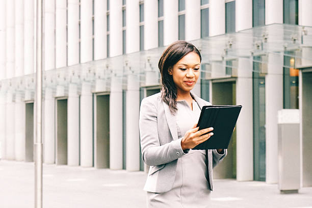 Portrait of successful businesswoman using tablet in urban landscape.