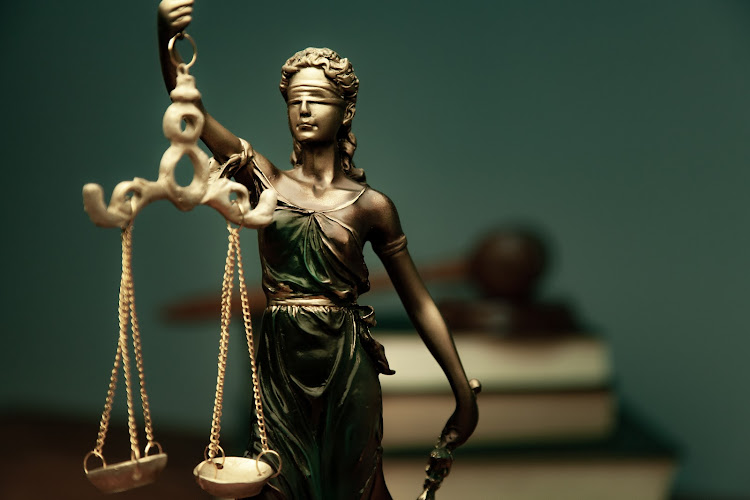 lady justice with book on dark background